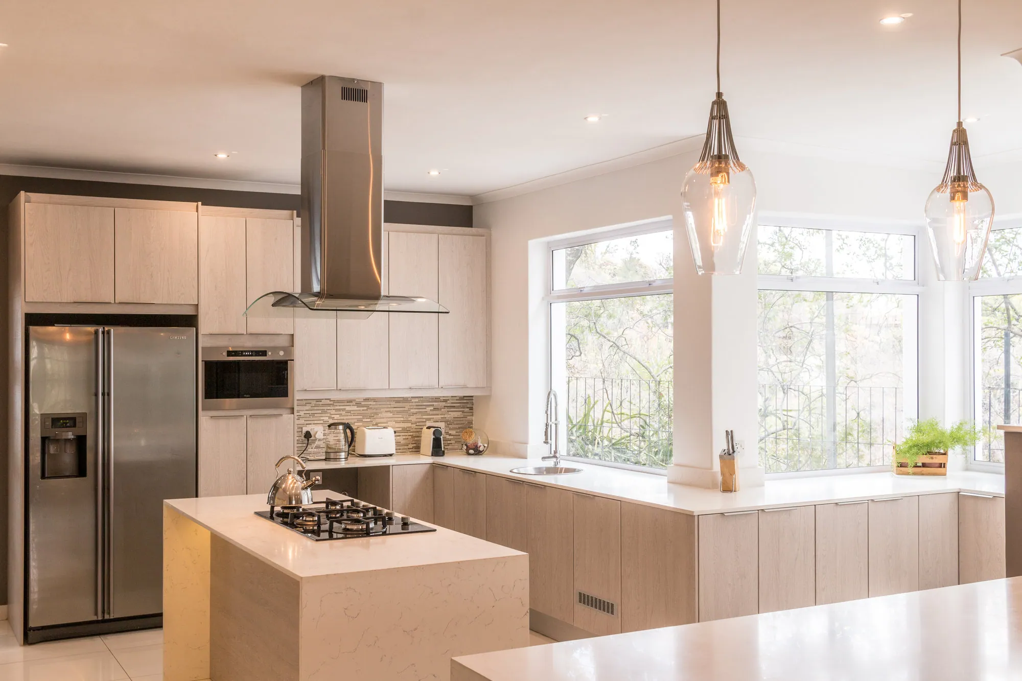 Kitchen island layout with gas hob and pendant lights