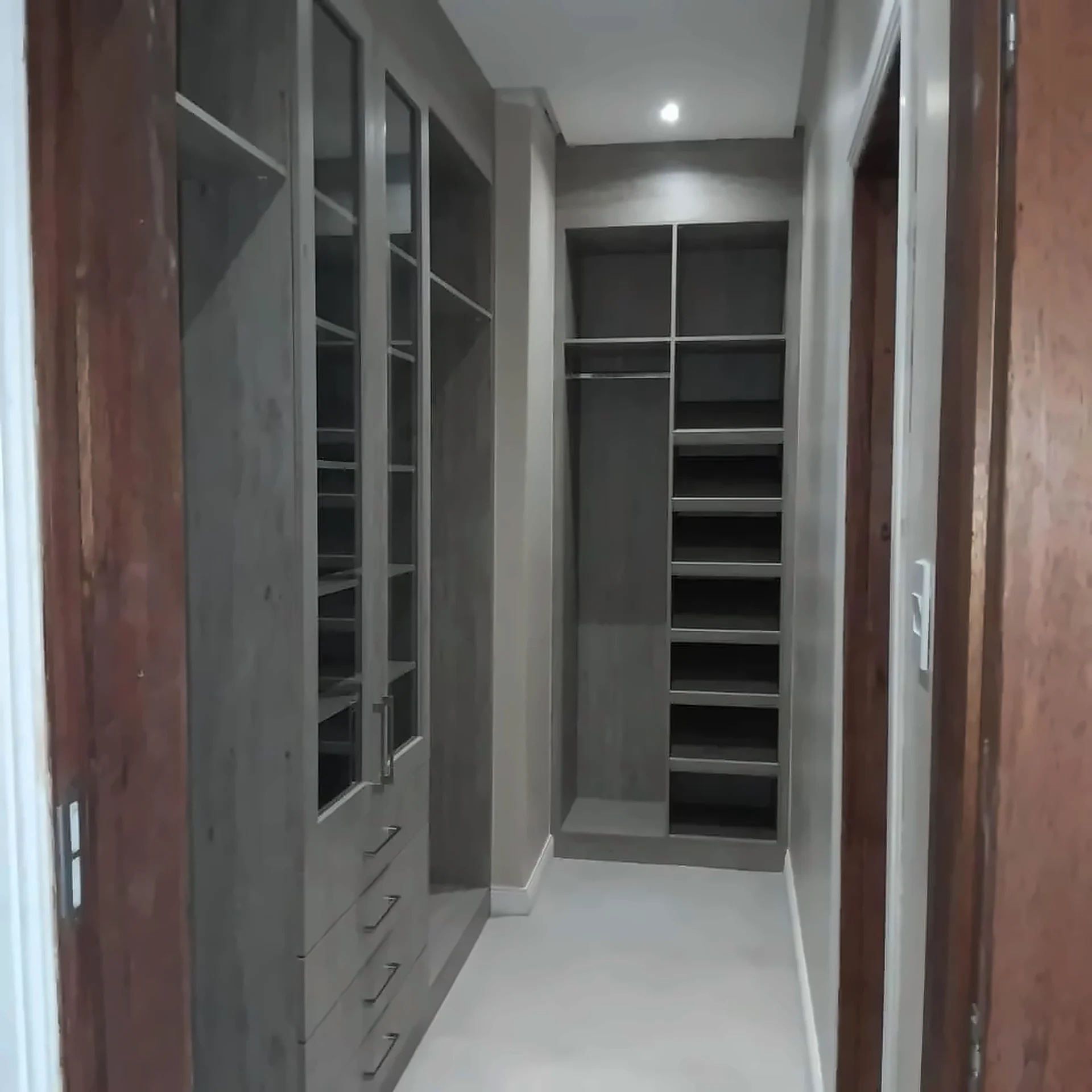 Walk-in dressing room with glazed units and open shelving