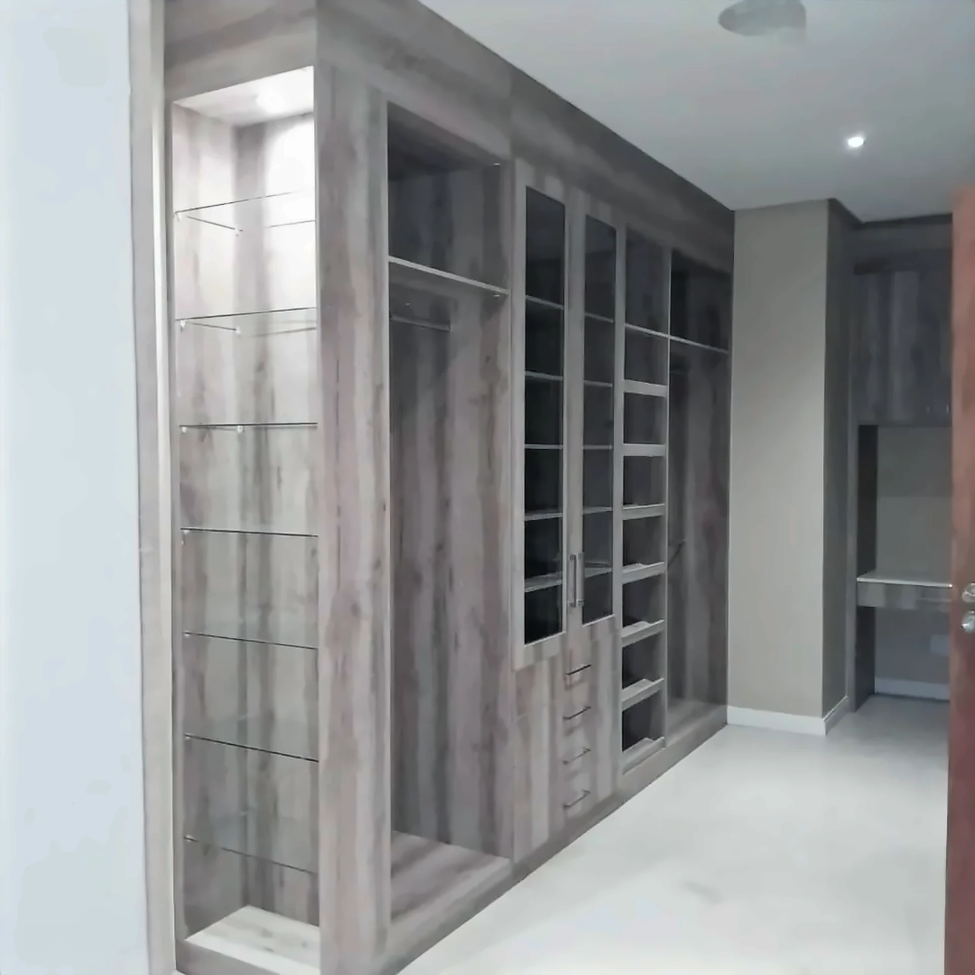 Walk-in dressing room with open shelving, glazed units and hanging space